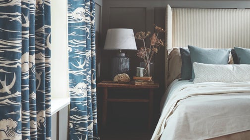 Blue curtains featured waves and sea birds in a blue-themed bedroom